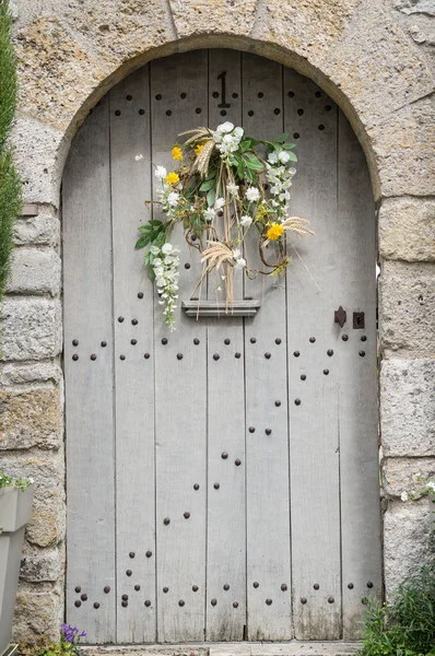 Wooden door decorated by flowers — Stock Photo, Image