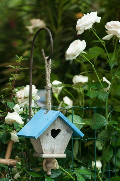 Vogelhaus mit weißen Blumen — Stockfoto