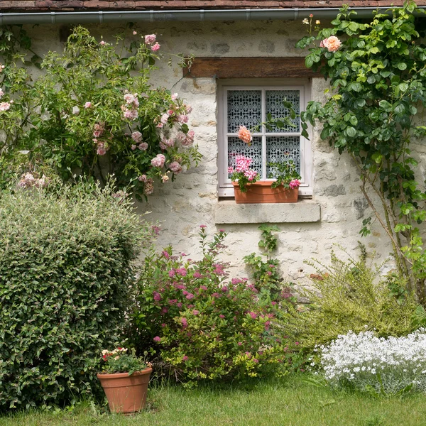 Çiçeklerle süslenmiş küçük pencere — Stok fotoğraf