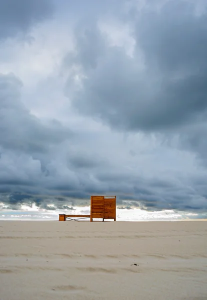 Драматический пасмурный минималистский вид на пляж с деревянной гардеробной. раздевалка — стоковое фото