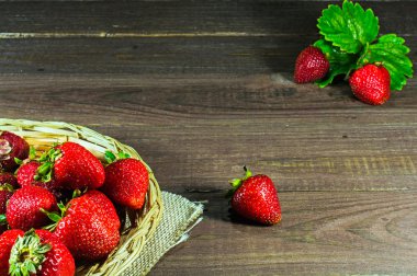 hasır sepet eski ahşap zemin üzerine taze olgun çilek