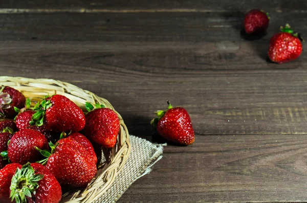 Fresas frescas maduras en canasta de mimbre sobre fondo de madera viejo — Foto de Stock