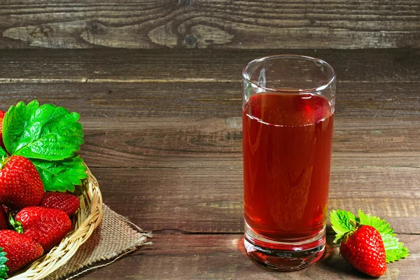 Zumo de fresa fresca con canasta de mimbre con fresas sobre fondo de madera vieja —  Fotos de Stock