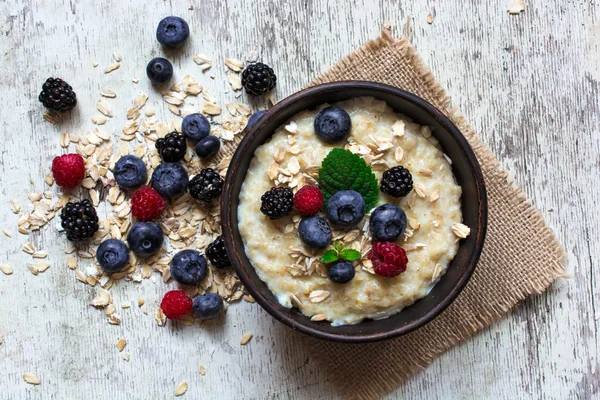 Oatmeal porridge with ripe berries for breakfast. top view — Stock Photo, Image