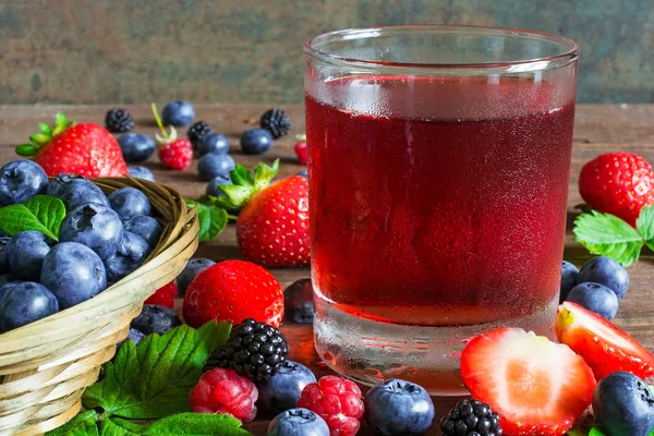 Jugo fresco de bayas frías de verano en un vaso con bayas maduras en —  Fotos de Stock