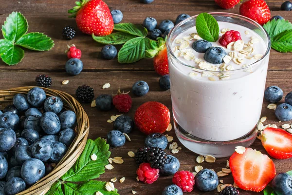 Bicchiere di yogurt con mirtilli freschi interi, more, raspa — Foto Stock