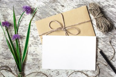 Boş beyaz tebrik kartı ve mor çiçekler ile zarf