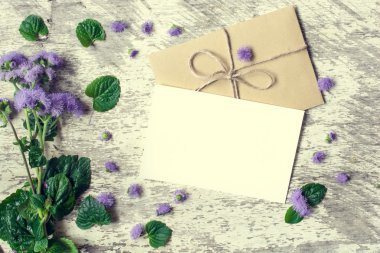 Boş beyaz tebrik kartı ve mor çiçekler ile zarf