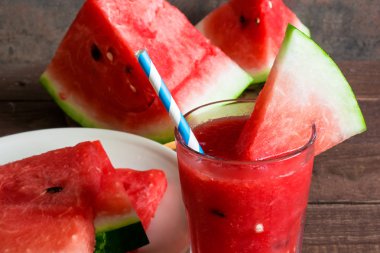 Ahşap arka plan üzerinde bir saman ile karpuz güler yüzlü