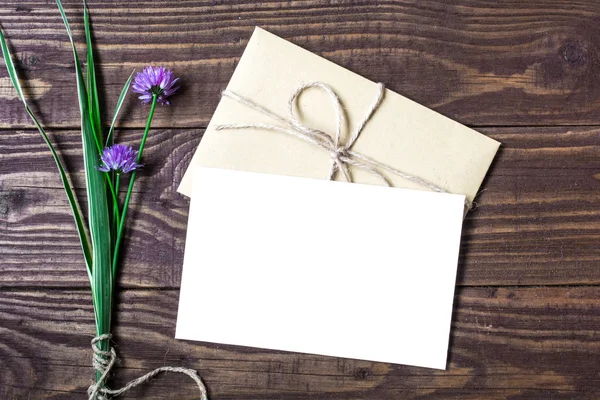 Boş beyaz tebrik kartı ve mor çiçekler ile zarf — Stok fotoğraf