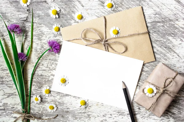 Üres üdvözlőlap és boríték fehér Kamilla virág és lila vadvirágok — Stock Fotó
