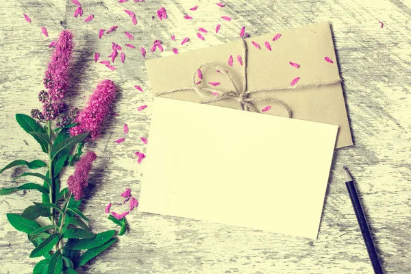 Puste, białe z życzeniami, koperty i ołówek z purpurowe kwiaty — Zdjęcie stockowe