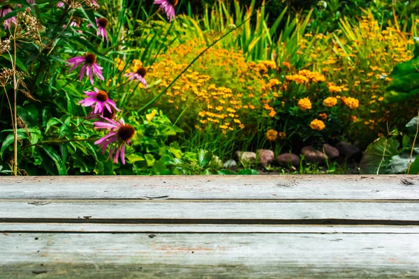 Расплывчатый осенний сад и деревянный стол — стоковое фото