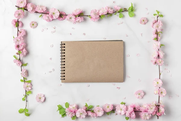 Blanco Papieren Notitieboekje Met Roze Bloemen Witte Marmeren Achtergrond Vrouwendag — Stockfoto