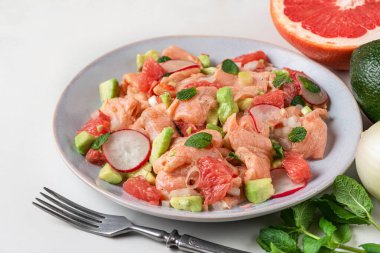 Greyfurt, avokado, turp, soğan ve çatallı naneli Şili somon ceviche 'si. Sağlıklı diyet yemekleri. Kapat.