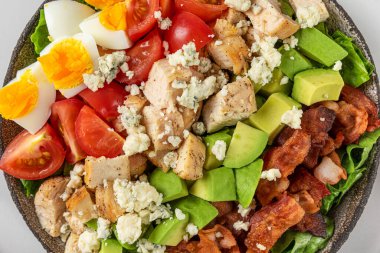 Izgara tavuk, pastırma, avokado, mavi peynir, domates ve yumurtalı Amerikan salatası yakın. Üst görünüm