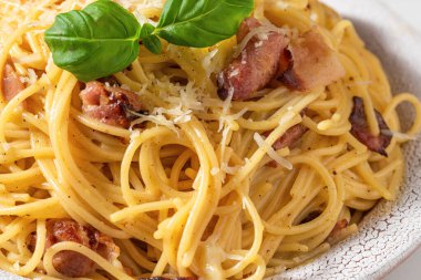 Pancetta, yumurta, parmesan peyniri, fesleğen ve krem soslu makarna. İtalyan yemeği. Kapat.
