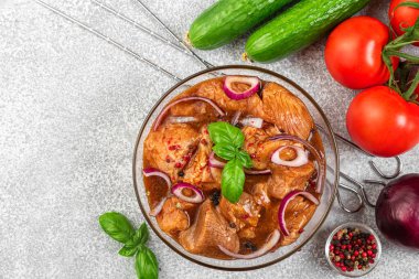 Taze sebzeli marine edilmiş et, bbq sosu, biber, soğan ve fesleğen, gri arka planda barbekü pişirmek için şişler. en üstteki görünüm