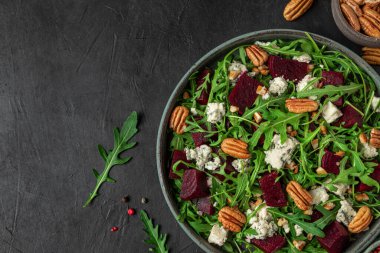 Taze roka salatası, pancar kökü, gorgonzola peyniri ve fındıklı fındık. Kopyalama alanı olan üst görünüm. sağlıklı vejetaryen yemekleri