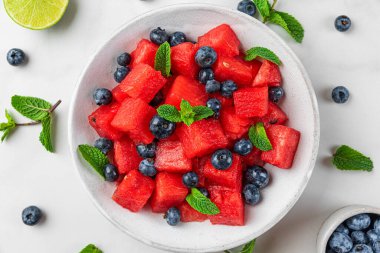 Beyaz mermer masada karpuz ve limon suyu ve nane şekerli yaban mersini yaz salatası. Üst Manzara. sağlıklı yiyecekler