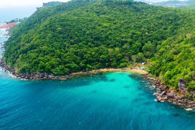 Vietnam 'daki Phu Quoc Adası' ndaki gizli tropikal kumlu plajın havadan görünüşü, yemyeşil yağmur ormanları, palmiye ağaçları ve berrak turkuaz deniz suyuyla çevrili. Sürdürülebilir turizm ve Asya 'da seyahat.