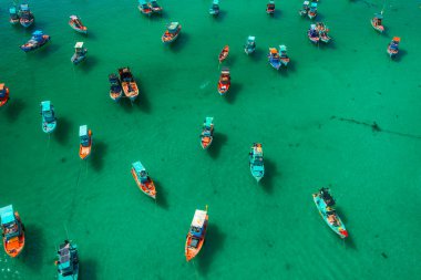 Temiz turkuaz suya demirlenmiş renkli balıkçı teknelerinin hava manzarası Phu Quoc Adası, Vietnam 'dan izleniyor. İHA görüntüsü. Geleneksel balıkçılık, sürdürülebilir yaşam, yavaş seyahat ve denizcilik