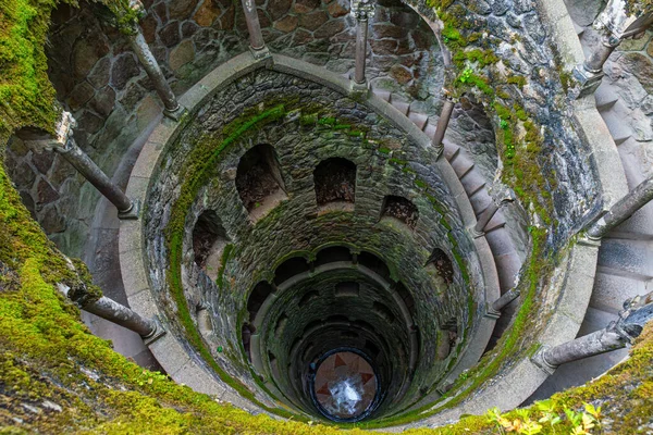 Portekiz 'in Sintra şehrindeki Quinta da Regaleira' daki Kabul Kuyusu 'nun içindeki spiral taş merdiven. Lisbon City yakınlarındaki bir parkta gotik mimari. Seyahat ve turistik dönüm noktası. Simetri, spiral biçimler