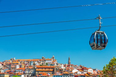 Porto, Portekiz 'deki kırmızı çatıları ve kiliseleri olan tarihi şehir merkezinin üzerinde kablo araba kulübesi. Modern turizm teknolojisi ve ekolojik ulaşım. Sürdürülebilir seyahat. Portekizli Oporto eski kasabası