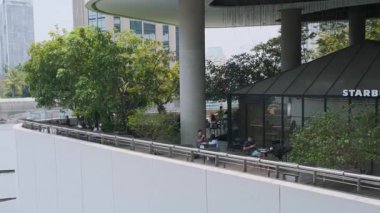 Bangkok, Tayland - 20 Mart 2025: Starbucks Kafe, Bangkok 'taki modern alışveriş merkezinin terasında yeşil alanlarla çevrili oturma alanı. Kentsel dinlenme kafe ve biyofilik reklam