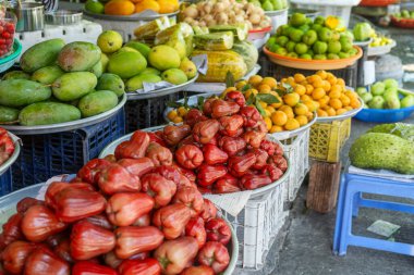 Vibrant display of fresh tropical fruits for sale at traditional food market in Phu Quoc, Vietnam. Rose apples, mangoes and loquats displayed at Vietnamese street market. Agriculture, farming and