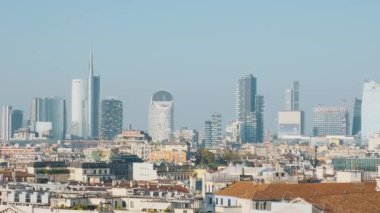 Milano şehrinin modern gökdelenleri ve açık mavi gökyüzü altında geleneksel çatıları olan gökdelenleri, Lombardy, İtalya. Modern mimari, kentsel ufuk çizgisi ve seyahat noktası.