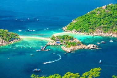 Turkuaz lagünlerle, beyaz kumsallarla, yeşil tepelerle ve açık mavi denizdeki teknelerle tropik Nang Yuan Adası 'nın havadan görünüşü. Koh Samui yakınlarında şnorkelle yüzmek ve dalmak için mercan adası. Seyahat