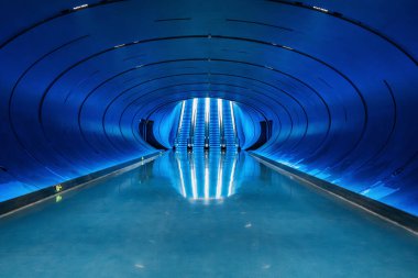 Mavi ışıklı yürüyen merdivenleri, kıvrımlı tüneli ve Çin 'in Chengdu şehrinde yansıtıcı zemini olan fütüristik mavi aydınlatma alanı. Simetri, altyapı, teknoloji, yenilik ve modernite