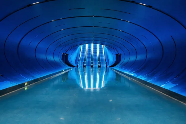 Mavi ışıklı yürüyen merdivenleri, kıvrımlı tüneli ve Çin 'in Chengdu şehrinde yansıtıcı zemini olan fütüristik mavi aydınlatma alanı. Simetri, altyapı, teknoloji, yenilik ve modernite