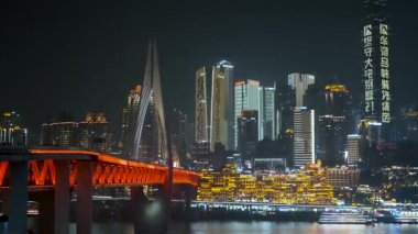 Chongqing, Çin - 08 Aralık 2025: Qiansimen köprüsü ile aydınlanan Chongqing gece şehri ve Hongya Mağarası ve modern gökdelenleri ile Jialing Nehri üzerinde parlayan gökyüzü. Tarihi Çince