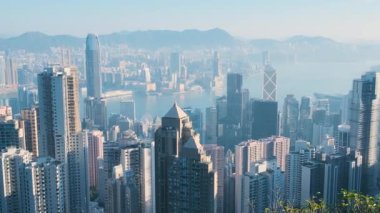 Hong Kong şehrinin silueti ve Victoria Limanı güneş doğarken Victoria Tepesi 'nin yamaçlarından görüldü. Küresel finans merkezi ve modern ekonomi. Hava görünümü.