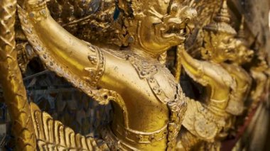 Bangkok, Tayland 'daki en kutsal Budist tapınağı olan Zümrüt Buda Tapınağı Wat Phra Kaew' in dış duvarlarını süsleyen Altın Garuda heykelleri. Detaylı Tayland mitolojisi