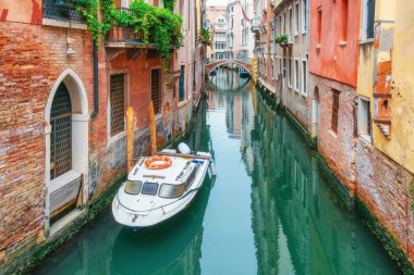 Venedik kanalı, küçük motorlu tekne, tarihi binalar ve geleneksel İtalyan şehir manzarasında taş köprü. Venezia 'nın eski kasabası. Avrupa 'da seyahat hedefi.
