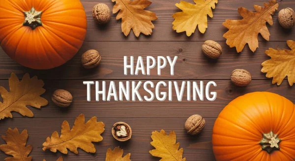 Tahta bir masanın üzerinde balkabağı, fındık ve sonbahar yaprakları olan Şükran Günü tebrik kartı. Resim bir ileti için kopyalama alanı olan düz bir üst görünüm.