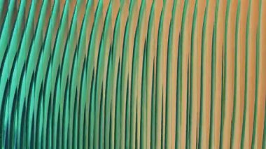 Yeşil ve turuncu tonlarda dikey dalgalı çizgiler içeren canlı ve soyut bir arkaplan dinamik bir doku yaratıyor. Modern tasarımlar ve sanatsal projeler için ideal.