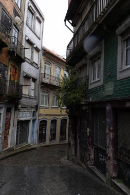 Çakıl taşı yolu olan, grafitiyle süslenmiş eski binalarla çevrili büyüleyici dar bir cadde..