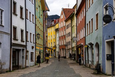 Cobblestone Yolu 'nun yer aldığı kentsel bir sokak manzarası. Canlı, renkli binalarla dolu. Fussen, Almanya 2 Mayıs 2023
