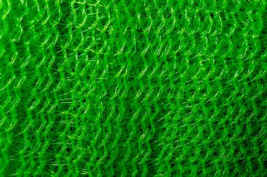 Canlı yeşil bir ağ desenine yakın çekim, soyut, desenli plastik bir yüzey oluşturur..