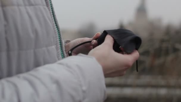 Chica limpieza gafas de lente en el parque en la ciudad — Vídeos de Stock