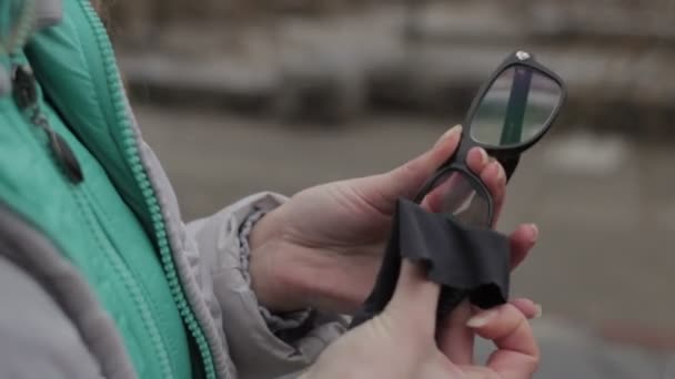 Chica limpieza gafas de lente en el parque en la ciudad — Vídeos de Stock