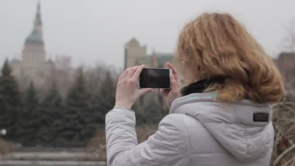 Chica rubia tomando fotos en la ciudad — Vídeo de stock