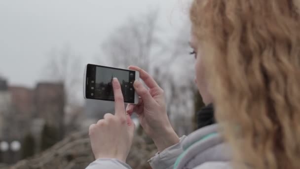 Chica rubia tomando fotos en la ciudad — Vídeo de stock