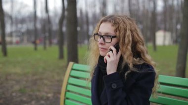 Genç kadın bir parkta açık havada telefonda söz