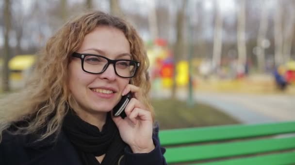 Jeune femme parlant au téléphone à l'extérieur dans un parc — Video