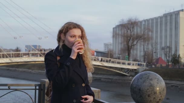 Meisje op een wandeling met een warme drank — Stockvideo